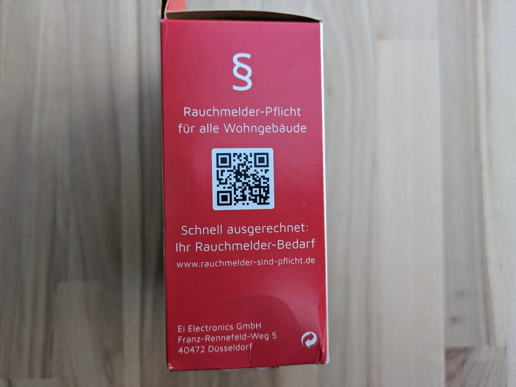 Verpackung des Ei Electronics Ei650 Rauchmelders von links