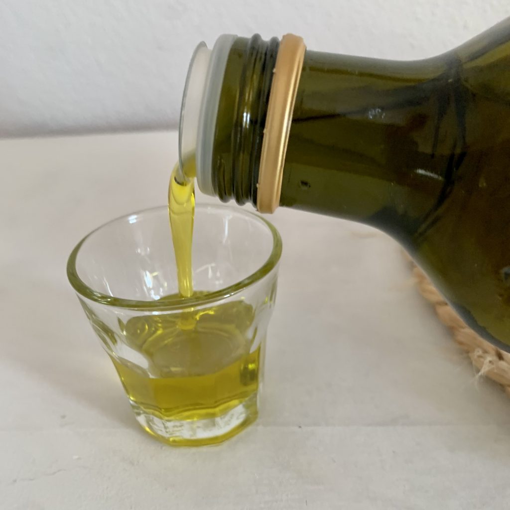 Filippo Berio Olio Natives Olivenöl extra beim Ausgießen in das Glas