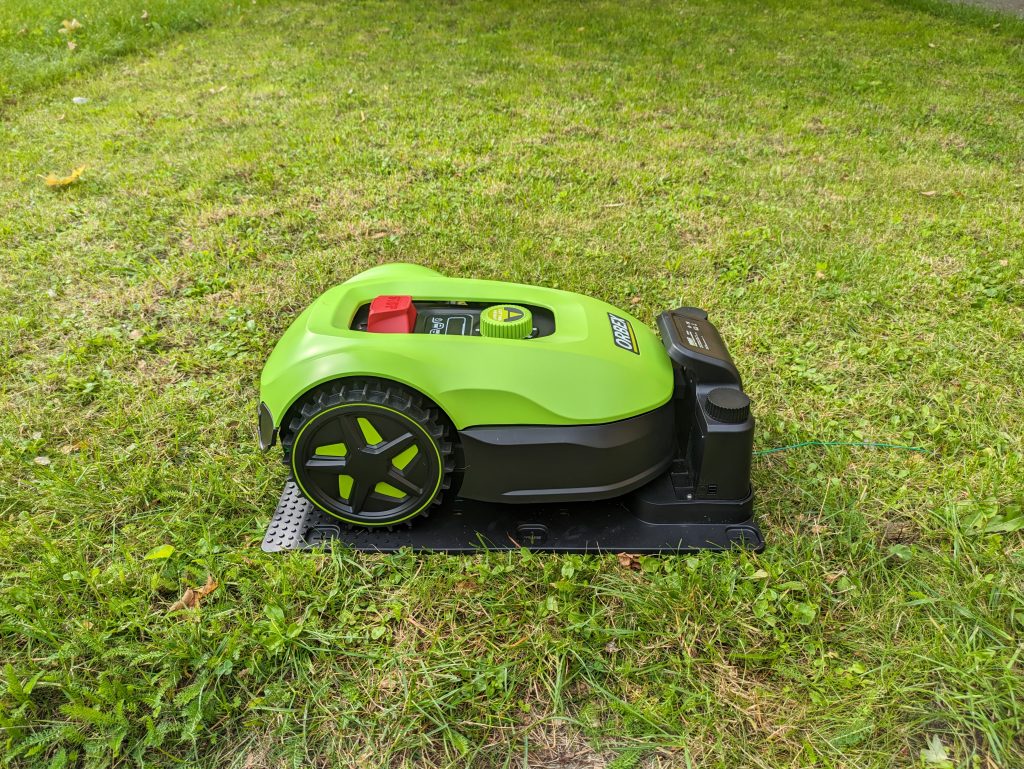 ORBEX S400G Mähroboter auf der Wiese und in der Ladestation