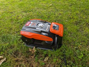 YARDFORCE COMPACT 300RBS Mähroboter auf der Wiese und in der Ladestation