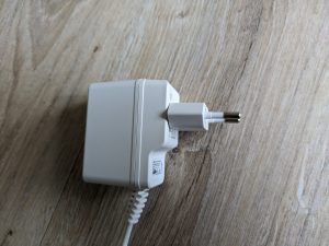 Netzteil der D-Link DCS 8620L Überwachungskamera mit aufgesteckten Schuko-Stecker