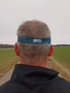 PETZL Tikka Stirnlampe, auf Kopf bei Mann, von hinten
