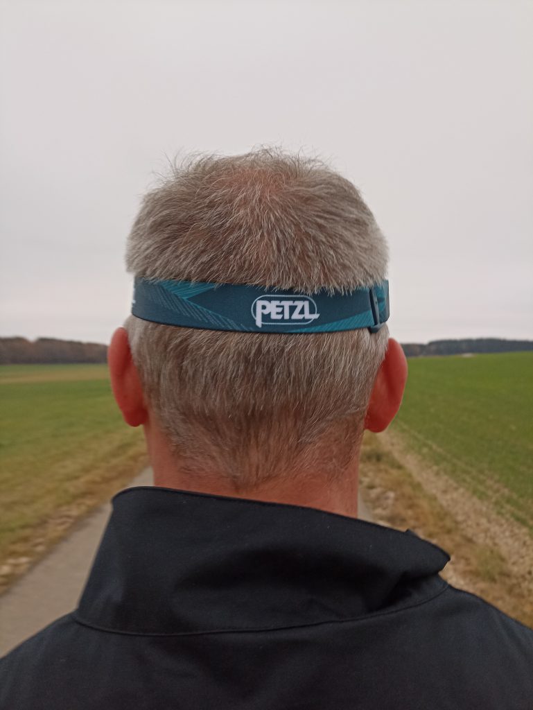 PETZL Tikka Stirnlampe, auf Kopf bei Mann, von hinten