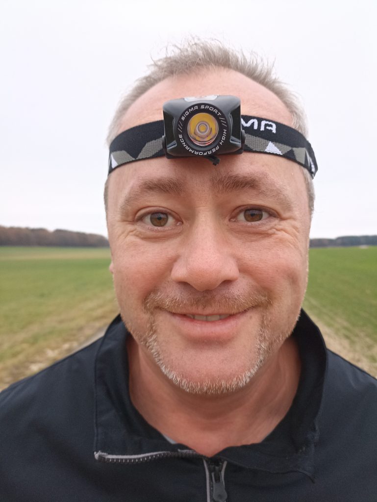 Sigma Sport Headled II Stirnlampe, auf Kopf bei Mann, von vorne
