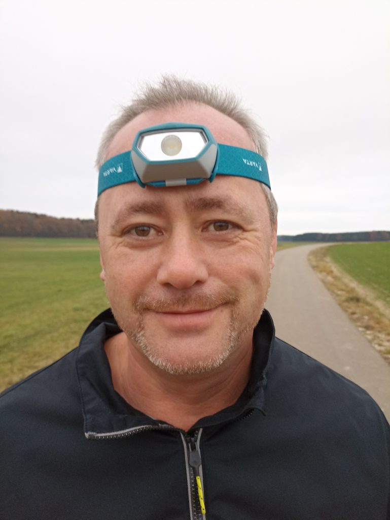 VARTA H10 Pro Stirnlampe, auf dem Kopf bei Mann, von vorne