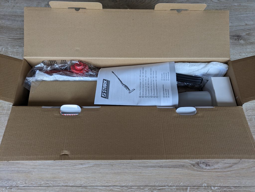 Geöffnete Verpackung des STARK WC 280 Home+ Fenstersaugers mit Anleitung