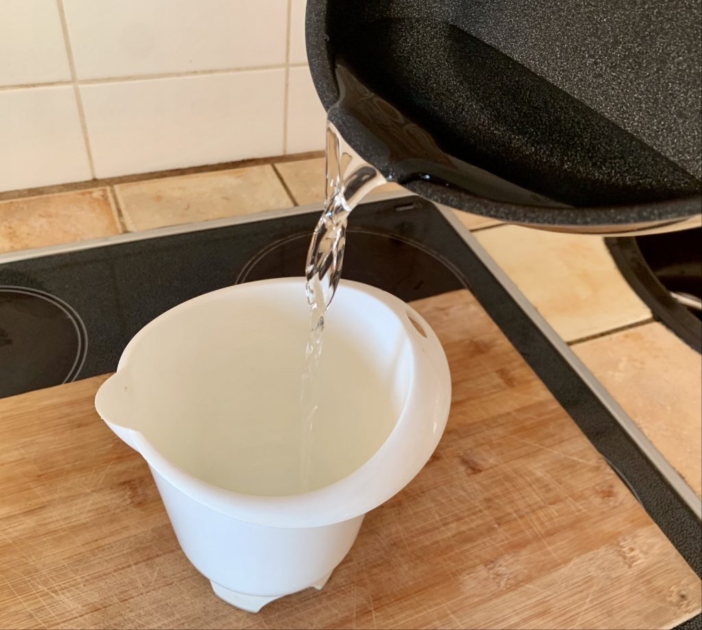 Woll Concept beschichtete Pfanne beim Ausgießen von Flüssigkeiten