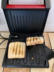 George Foreman 25030-56 Sandwichmaker beim Herausnehmen der Sandwiches