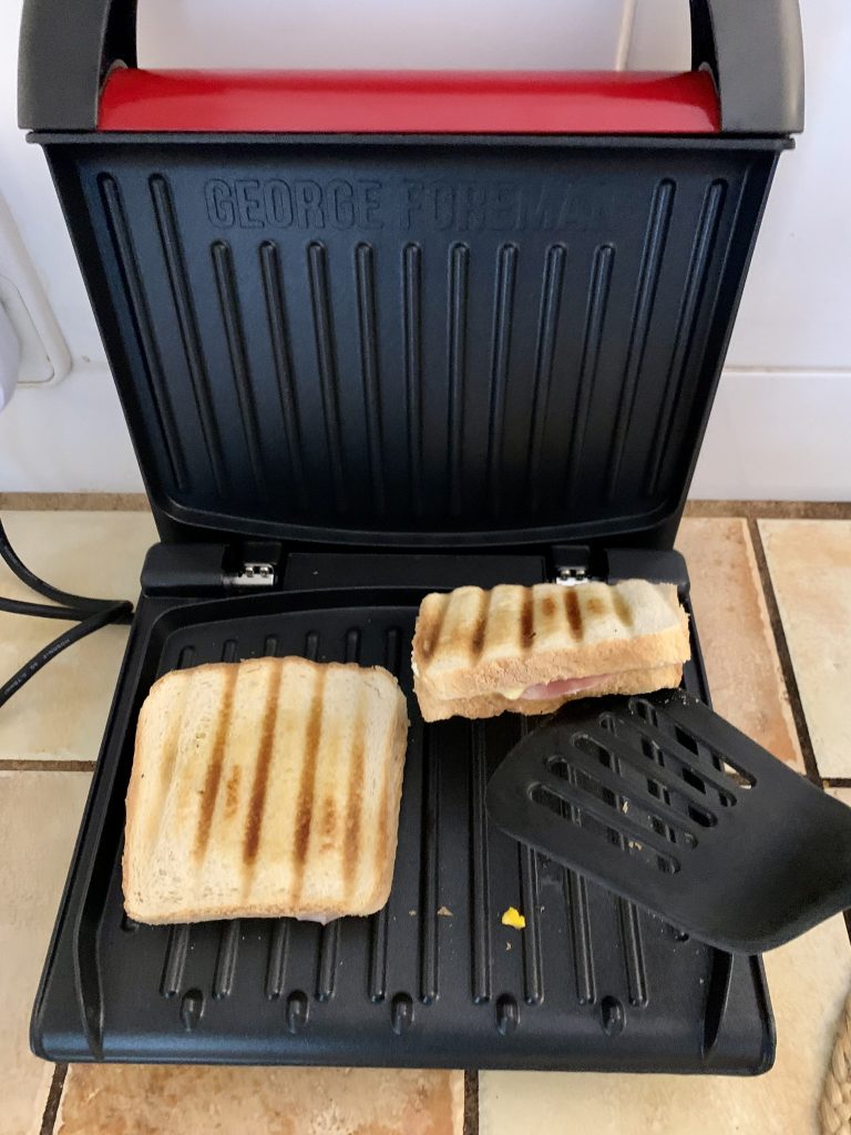 George Foreman 25030-56 Sandwichmaker beim Herausnehmen der Sandwiches