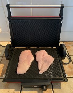 Bosch TCG4104 3-in1-Kontaktgrill mit zwei rohen Hähnchenfilets ohne Gewürze