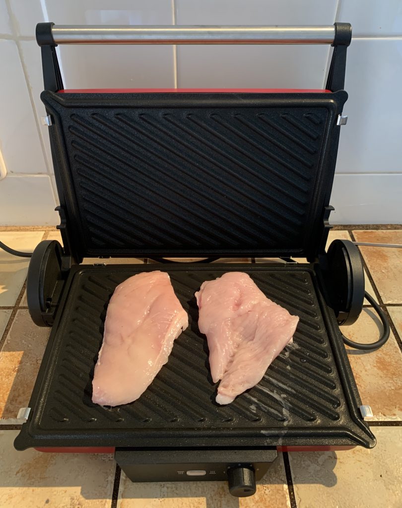 Bosch TCG4104 3-in1-Kontaktgrill mit zwei rohen Hähnchenfilets ohne Gewürze