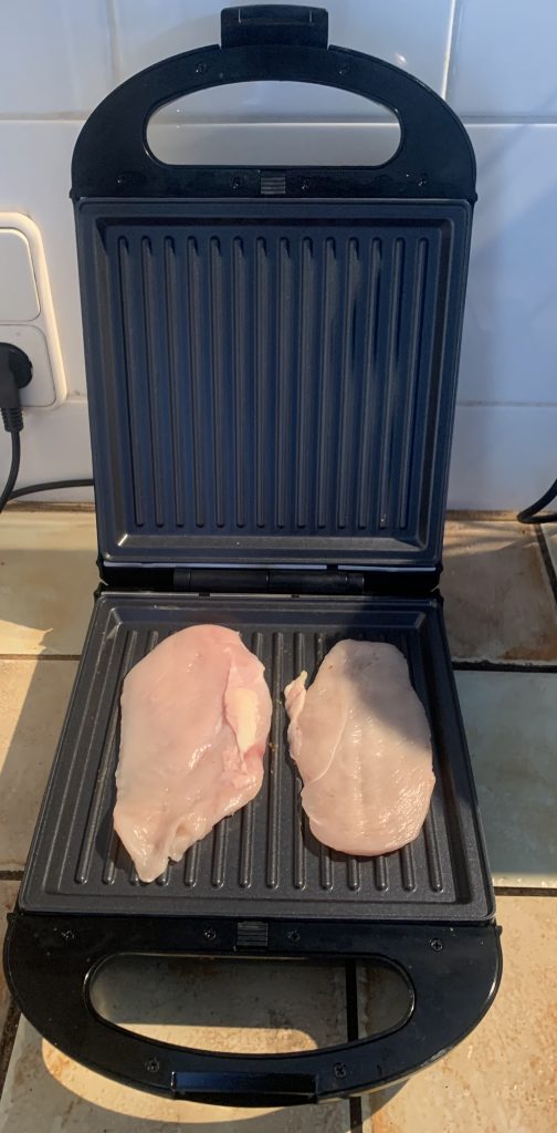 Steinborg SB2120 ist ein 3-in-1-Sandwichmaker mit Hühnerfilet auf den Grillplatten