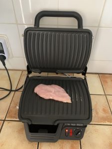Tefal GC3050 2-in-1-Kontaktgrill beim Aufheizen mit eingelgtem Hühnerfilet vor dem Grillen