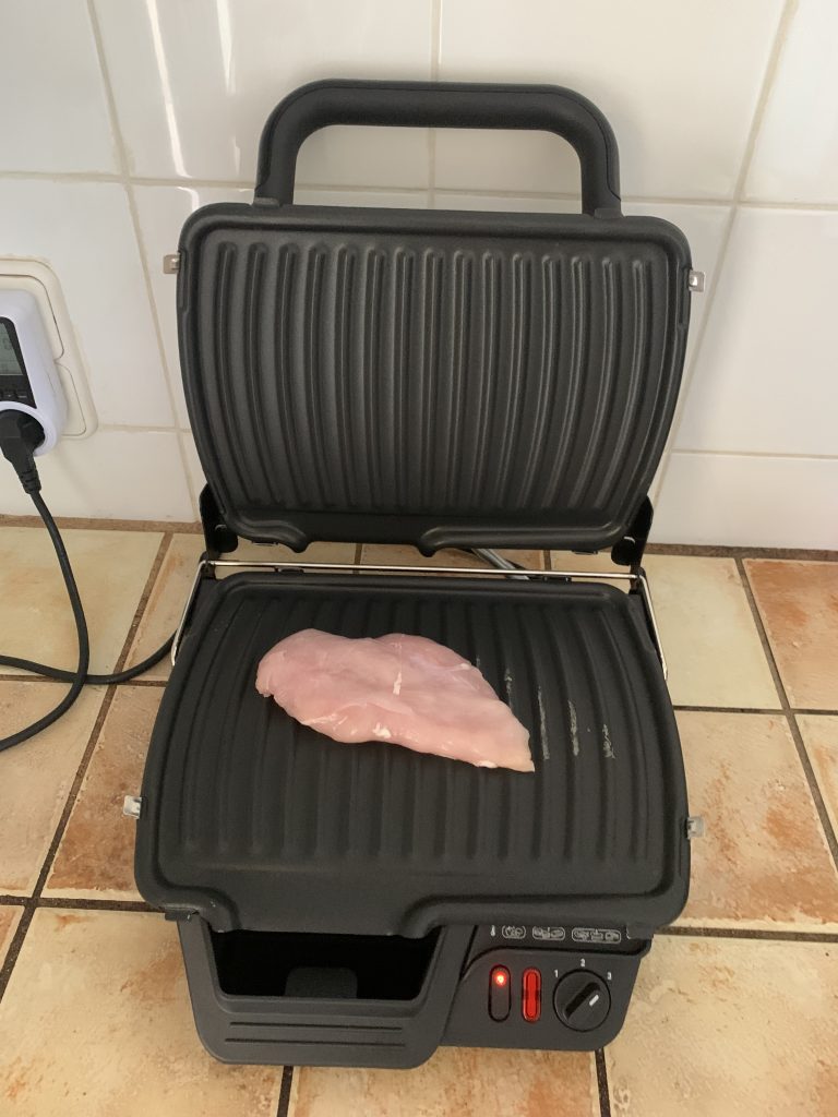 Tefal GC3050 2-in-1-Kontaktgrill beim Aufheizen mit eingelgtem Hühnerfilet vor dem Grillen