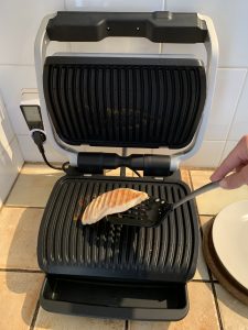 Tefal OptiGrill Elite GC750D16 Kontaktgrill beim Entnehmen des Hühnerfilets