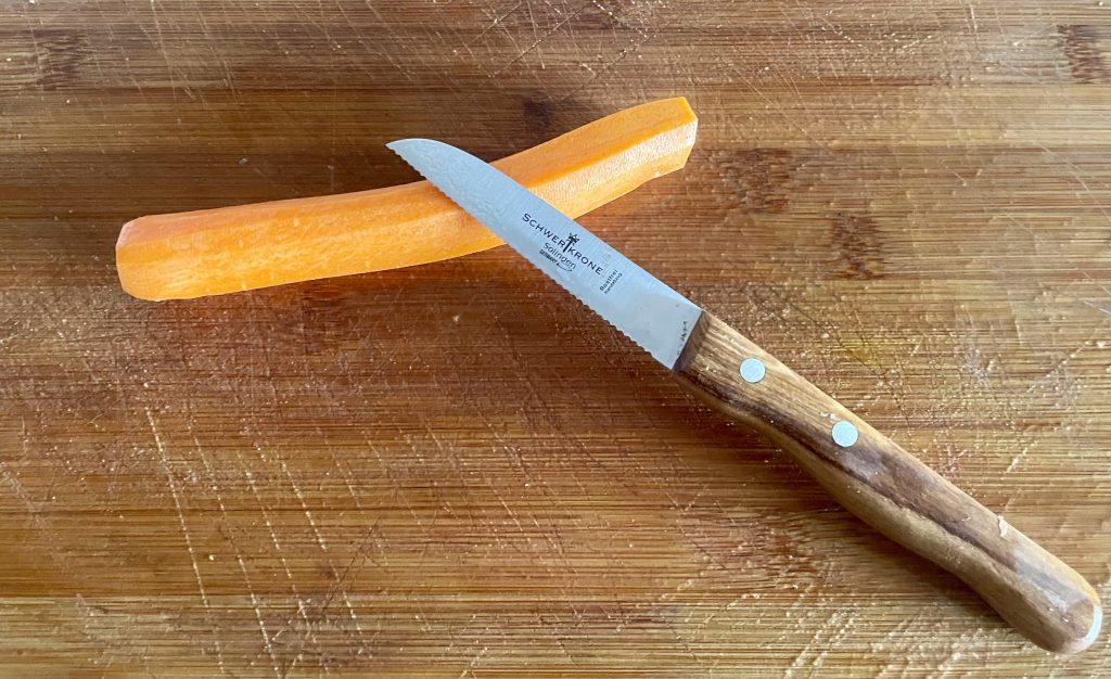 SCHWERTKRONE 1091 Küchenmesser vor dem Scheiden der Möhre