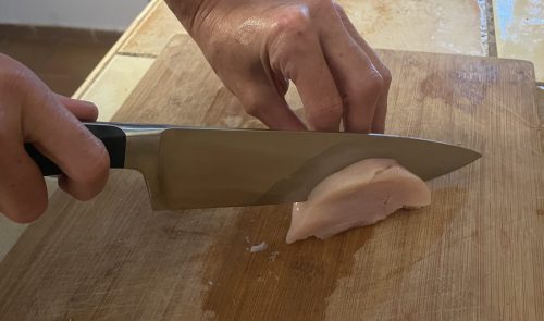 WÜSTHOF Classic Küchenmesser beim Schneiden von Fleisch