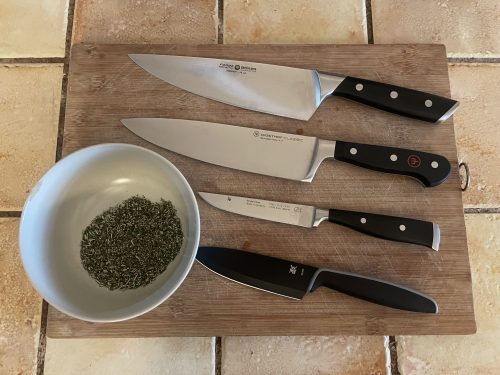 Küchenmesser-Gruppenbild mit Kräutern