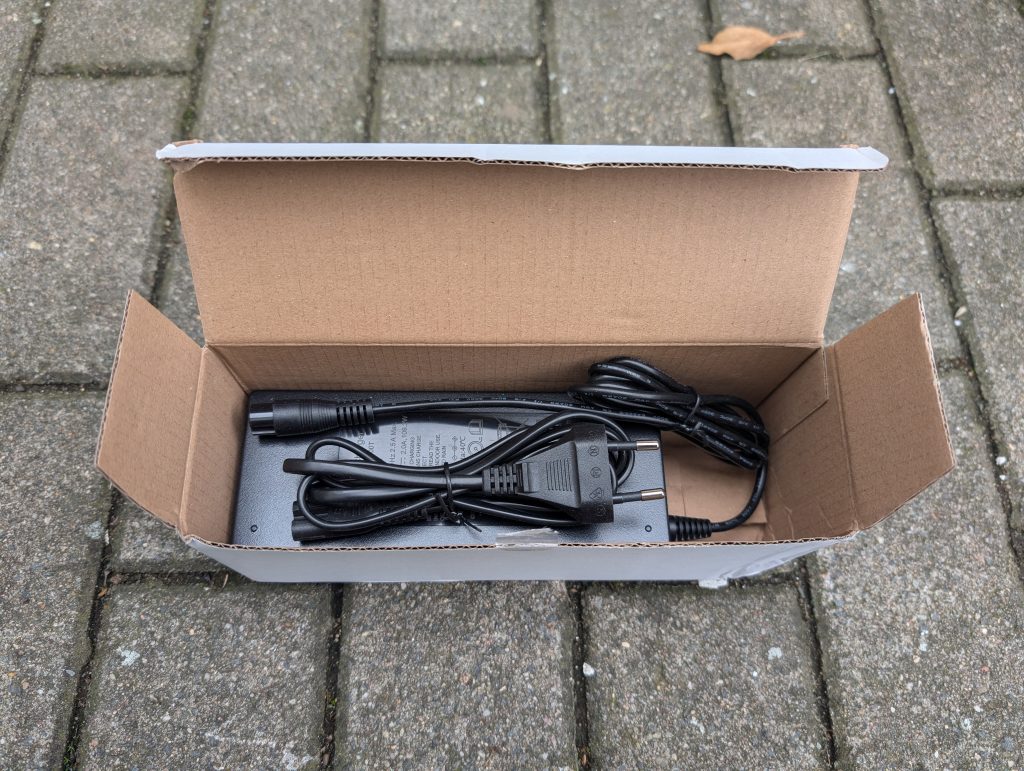 Ladegerät des Isinwheel T4 Elektro-Scooters in der Verpackung