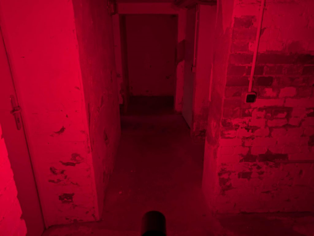 Roter Strahl der Ledlenser P9R Core LEP Taschenlampe im Keller