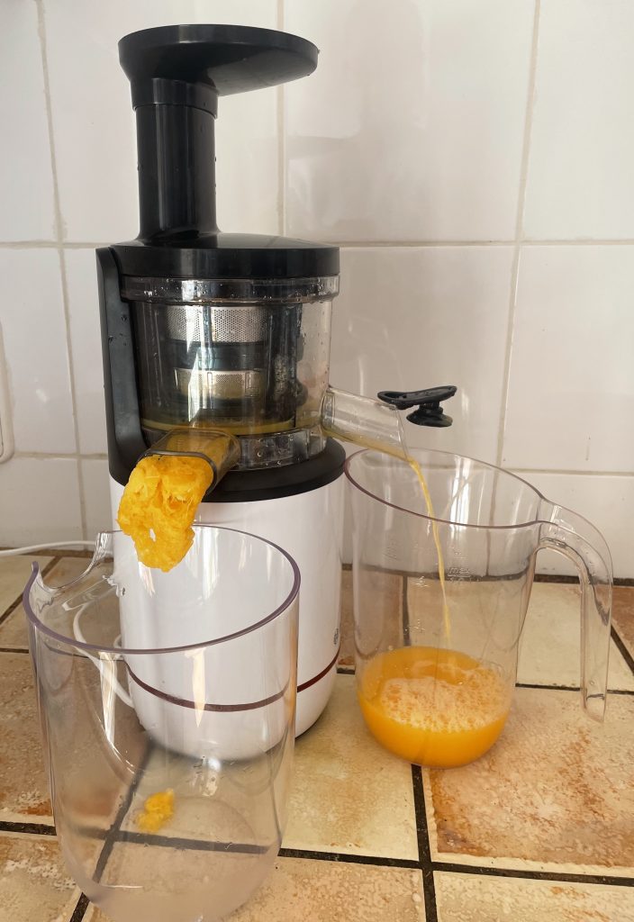 Bosch VitaExtract MESM500W Slow-Juicer beim Entsaften von Orangen mit geöffnetem Ausgusskanal