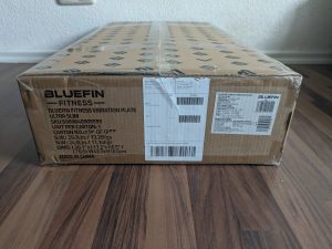 Verpackung der Bluefin Fitness SLIM Vibrationsplatte von der Seite