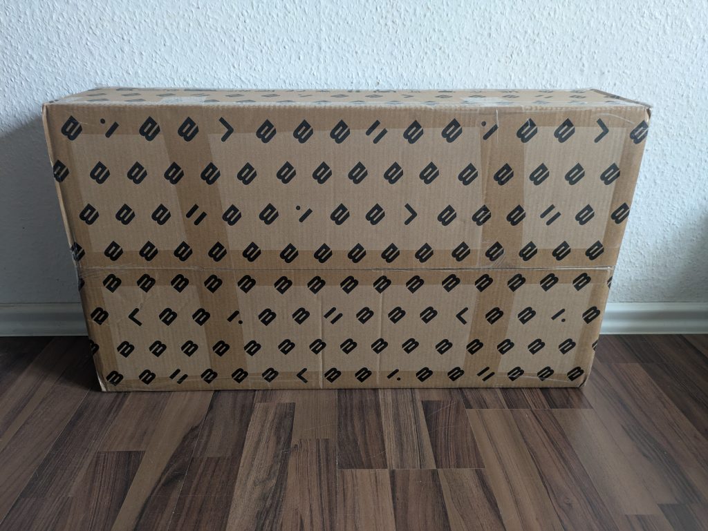 Verpackung der Bluefin Fitness SLIM Vibrationsplatte von vorne