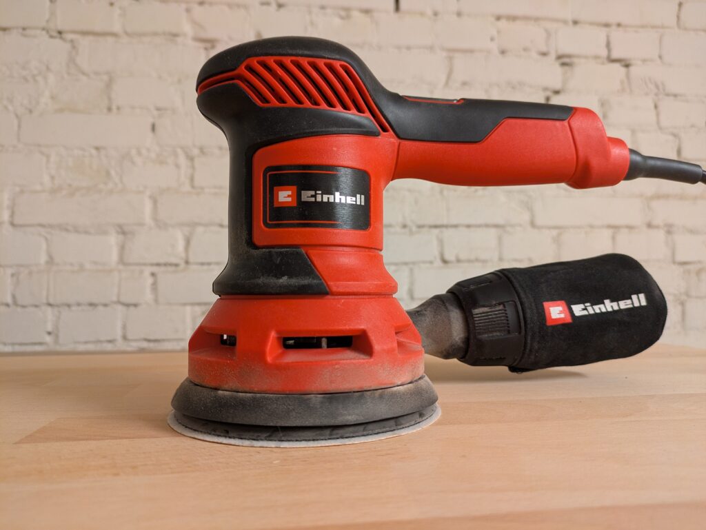 Einhell TC-RS 425 E Exzenterschleifer Titelbild mit Staub