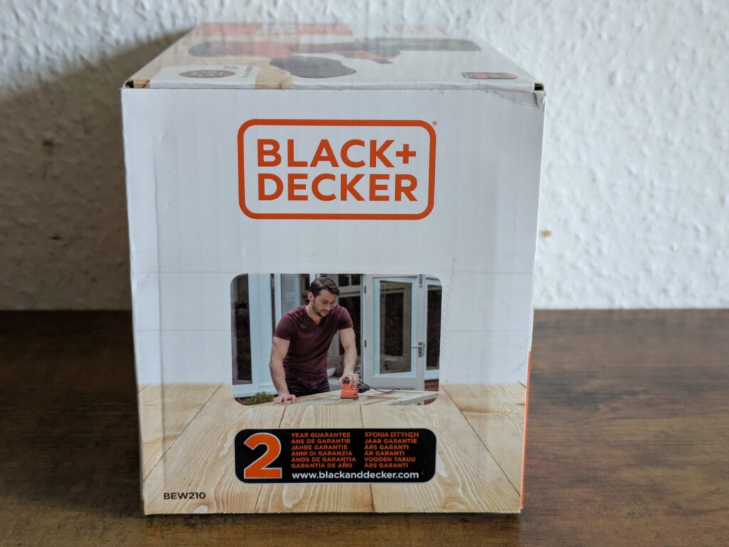 Verpackung des Black Decker BEW210 Exzenterschleifers von links