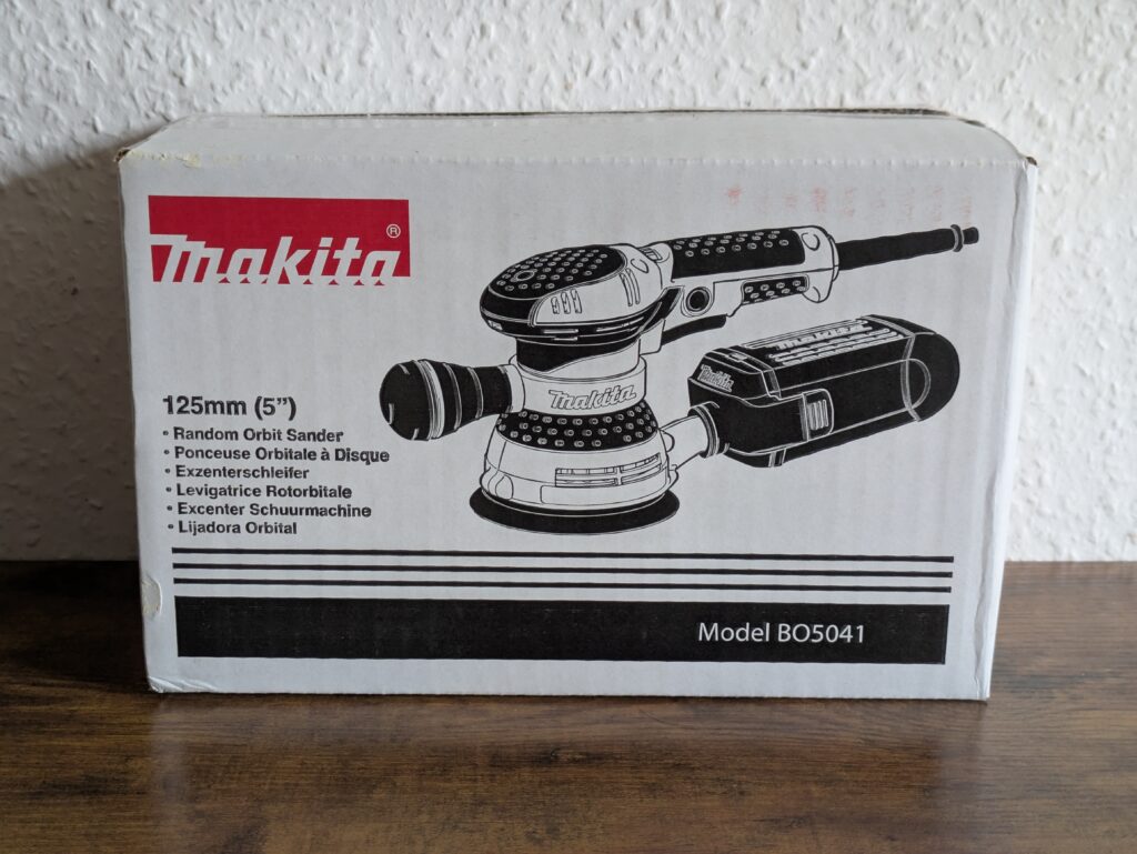 Verpackung des Makita BO5041 Exzenterschleifers von vorne