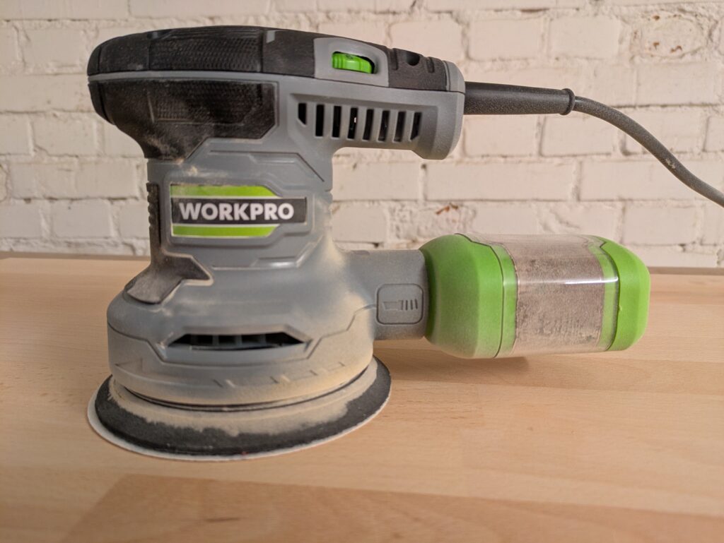 WORKPRO W125262 Exzenterschleifer Titelbild mit Staub