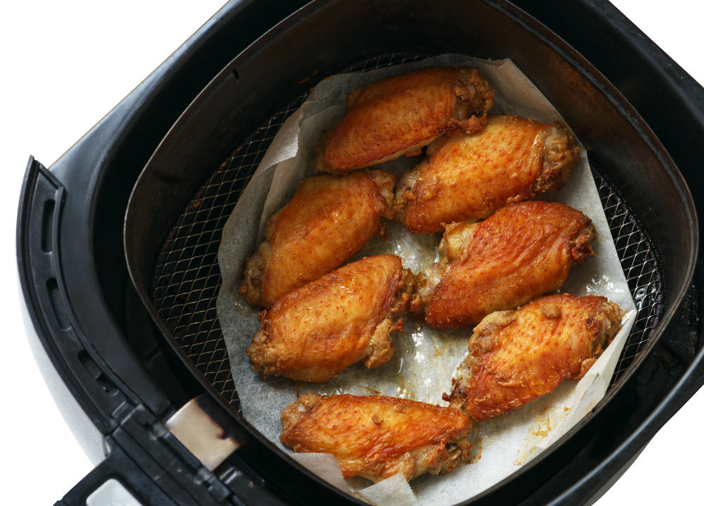 Hähnchenteile mit Backpapier in der Heißluftfritteuse